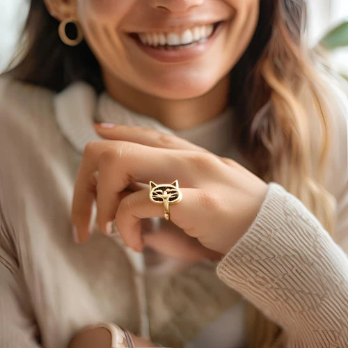 Bague dorée en forme de tête de chat portée par une femme, accessoire élégant pour les amoureux des félins