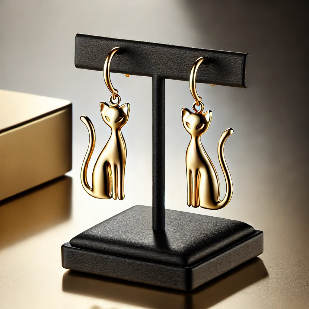 Boucles d’oreilles en or en forme de chat, affichées sur un support noir élégant, design raffiné et luxueux