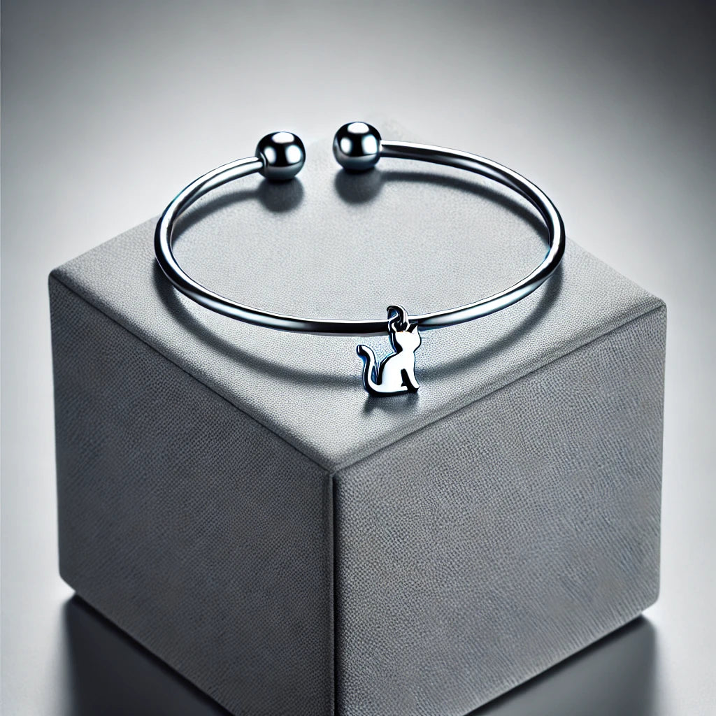 Bracelet en argent sterling avec un charm représentant une silhouette de chat, posé sur un support gris moderne, design élégant et raffiné